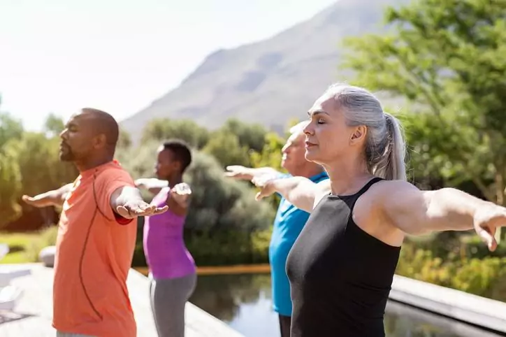 Calm image of meditating people at a retreat by a mountain